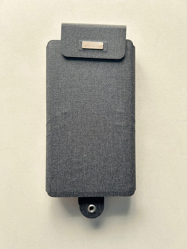Gray textured solar panel with a strap on a beige background
